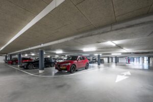 Moderne ondergrondse parkeergarage aan de De Cuserstraat met geparkeerde auto's.